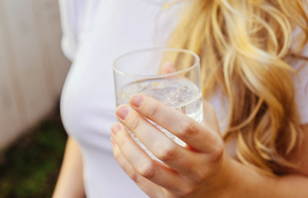 Woman holding a glass of water to stay hydrated